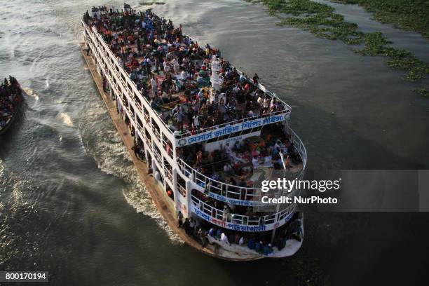 Bangladeshi travelers ride on an over crowed ferry as they go home to celebrate Eid-al-Fitr festival in Dhaka, Bangladesh on June 23, 2017. Muslims...