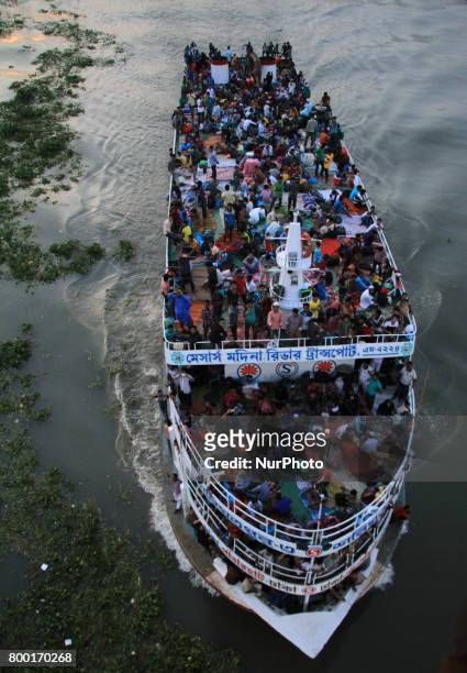 Bangladeshi travelers ride on an over crowed ferry as they go home to celebrate Eid-al-Fitr festival in Dhaka, Bangladesh on June 23, 2017. Muslims...