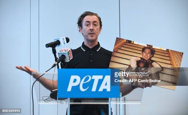 Actor Alan Cumming speaks while holding a photograph of himself with Tonka, his chimpanzee co-star from the 1997 film 'Buddy' during an announcement...