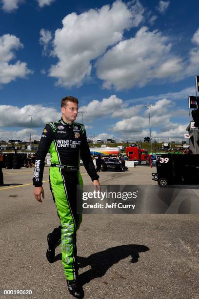 Dakoda Armstrong, driver of the WinField United Toyota, walks through the garage during practice for the NASCAR XFINITY Series American Ethanol E15...