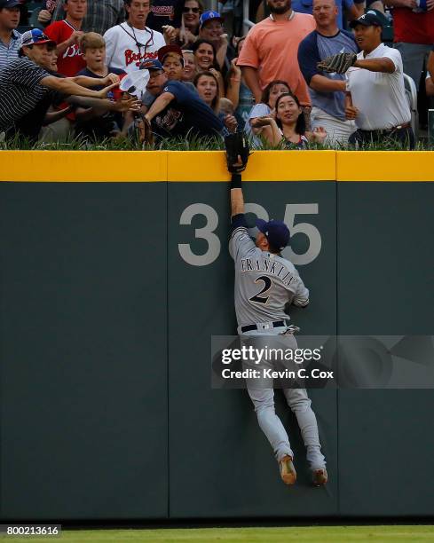 Nick Franklin of the Milwaukee Brewers attempts to catch a solo homer hit by Brandon Phillips of the Atlanta Braves in the first inning at SunTrust...