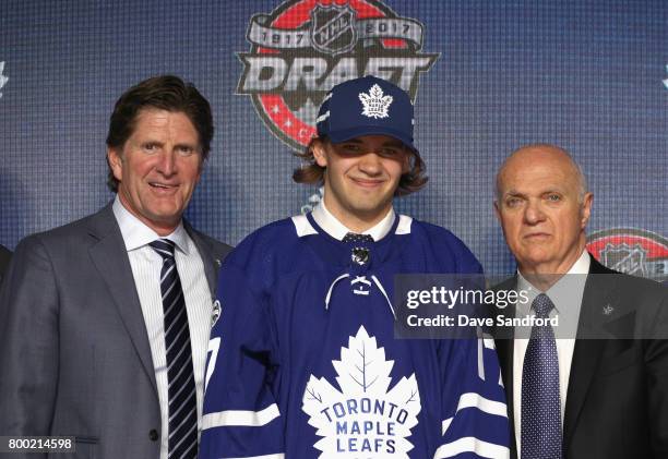 Head coach Mike Babcock, Timothy Liljegren, 17th overall pick of the Toronto Maple Leafs, and general manager Lou Lamoriello pose for a photo onstage...