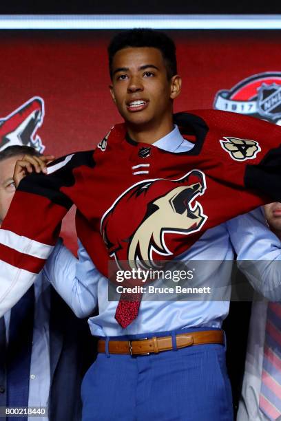 Pierre-Olivier Joseph puts on the Arizona Coyotes jersey after being selected 23rd overall during the 2017 NHL Draft at the United Center on June 23,...