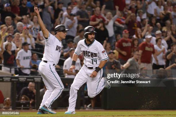 Reymond Fuentes of the Arizona Diamondbacks rounds third base in front of third base coach Tony Perezchica to score in the eighth inning of the MLB...