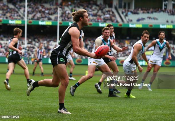 Tim Broomhead of the Magpies handballs during the round 14 AFL match between the Collingwood Magpies and the Port Adelaide Power at Melbourne Cricket...