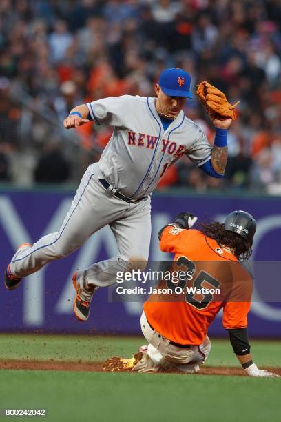 Brandon Crawford of the San Francisco Giants slides into second base to break up a double play attempt by Asdrubal Cabrera of the New York Mets...