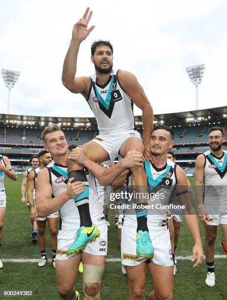 Paddy Ryder of the Power is chaired off by teammates after playing his 200th match during the round 14 AFL match between the Collingwood Magpies and...