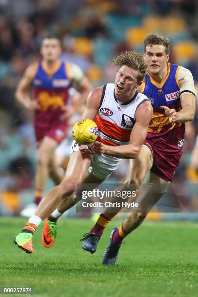 Lachie Whitfield of the Giants handballs during the round 14 AFL match between the Brisbane Lions and the Greater Western Sydney Giants at The Gabba...