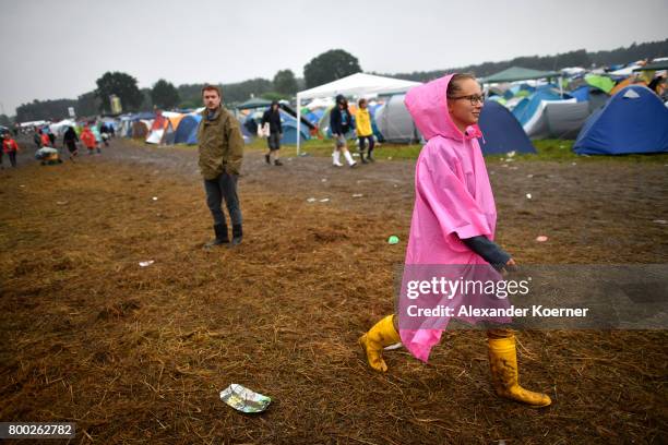 Festival goer walks through rain and mud at the camp site of the Hurricane Festival 2017 after a night full of heavy rain and winds on June 24, 2017...