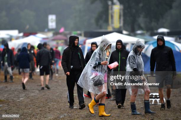 Festival goer walk through rain and mud at the camp site of the Hurricane Festival 2017 after a night full of heavy rain and winds on June 24, 2017...