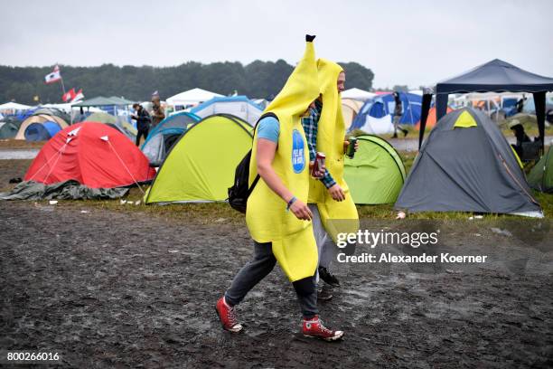 Festival goer wearing a banana costume while walking through rain and mud at the camp site of the Hurricane Festival 2017 after a night full of heavy...