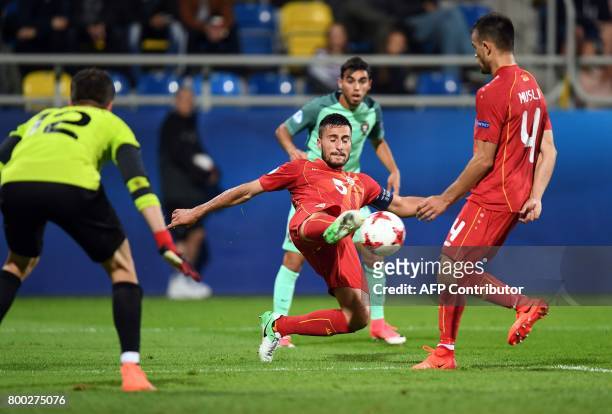 Macedonia's defender Gjoko Zajkov clears in front of the goal of Macedonia's goalkeeper Damjan Siskovski during the UEFA U-21 European Championship...