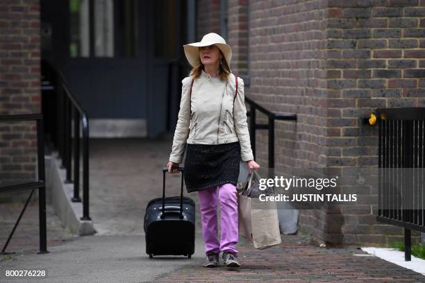 Resident with belongings leaves Taplow Tower residential block on the Chalcots Estate in north London on June 24, 2017 as residents evacuate because...
