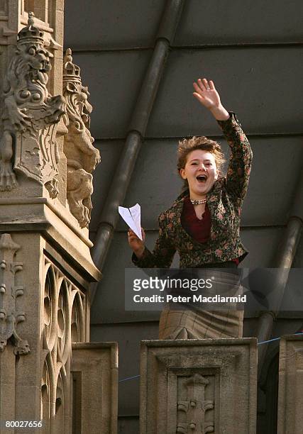 Protestor waves a paper aeroplane as she occupies the roof of Parliament on February 27, 2008 in London. The demonstrators from action group 'Plane...