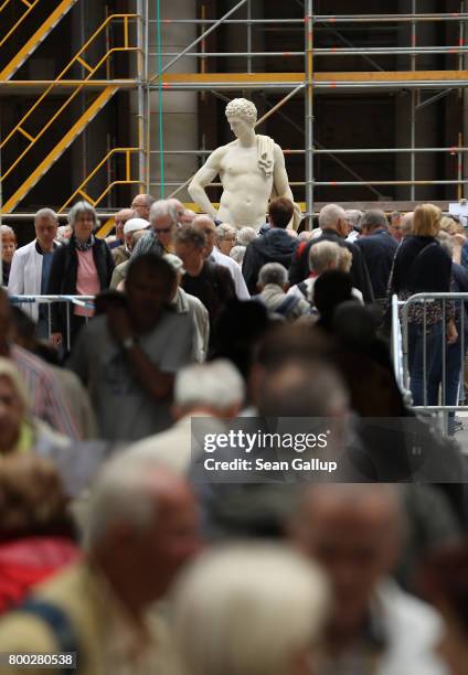 Visitors walk past a statue in the Schlueterhof courtyard during open house day at the construction site of the Berlin City Palace, which will house...