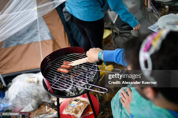 Festival goer prepares breakfast at a bbq at the camp site of the Hurricane Festival 2017 after a night full of heavy rain and winds on June 24, 2017...