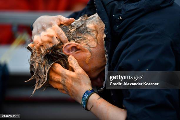 Festival goer washes his hair outdoor at the camp site of the Hurricane Festival 2017 after a night full of heavy rain and winds on June 24, 2017 in...