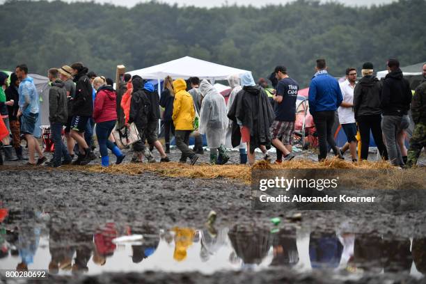 Festival goers stand in line for a makeshift supermarket at the camp site of the Hurricane Festival 2017 after a night full of heavy rain and winds...