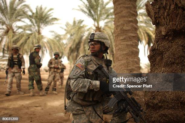 Sgt. Jonathan Silva-Mateo, with the Army 2-1 Cavalry and of Miami Beach, Florida, helps clear a village with the Iraqi Army February 27, 2008 in...