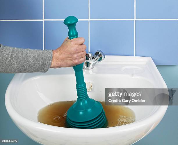 using a plunger to unblock a sink - sink stock pictures, royalty-free photos & images