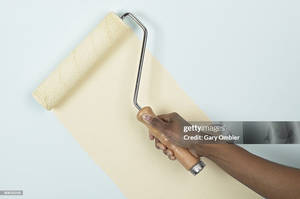 Applying paint to a wall with a roller