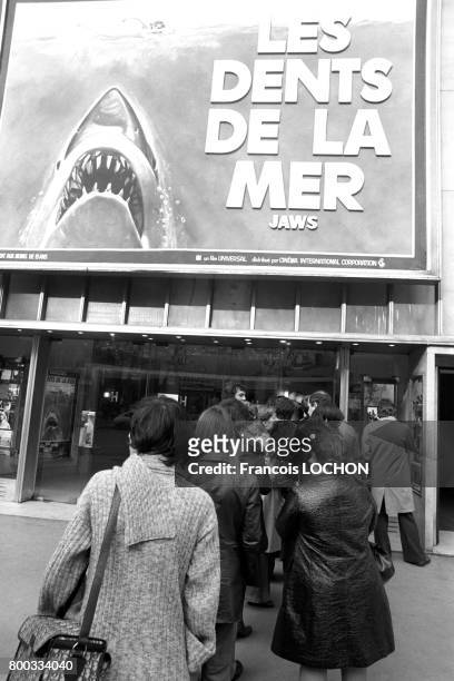 File devant un cinéma des Champs-Elysées affichant le film 'Les Dents de la mer' en février 1976 à Paris, France.