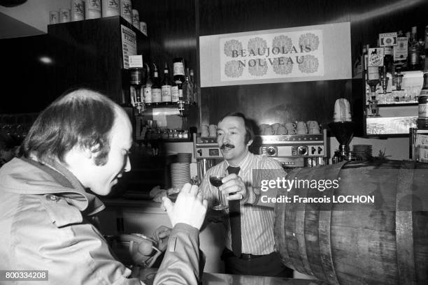 Un client s'apprête à goûter le Beaujolais nouveau dans un bar en novembre 1975 à Paris, France.