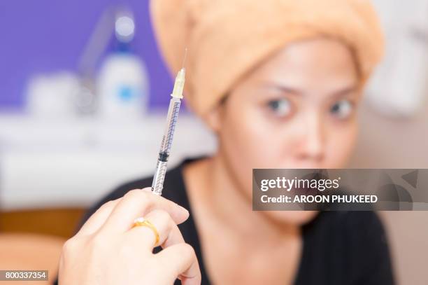 scared young woman looking having beauty cosmetic injection of botox - asian woman beauty shot photos et images de collection