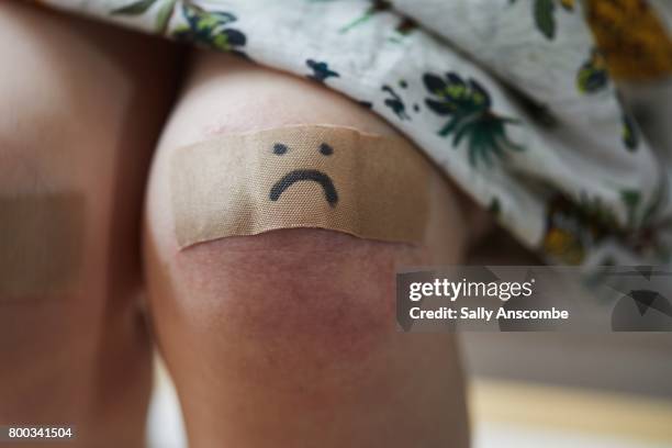 child with a plaster on her knee - patch stock-fotos und bilder