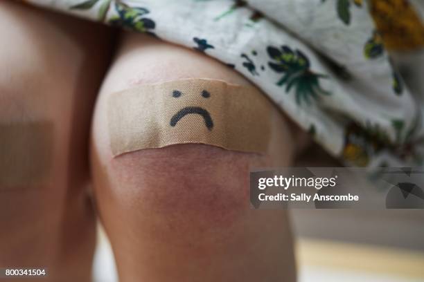 child with a plaster on her knee - ferido imagens e fotografias de stock