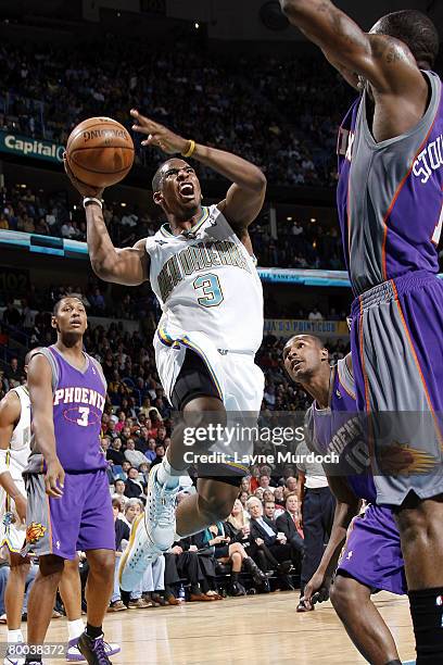 Chris Paul of the New Orleans Hornets goes up for a shot over Leandro Barbosa and Amare Stoudemire of the Phoenix Suns on February 27, 2008 at the...