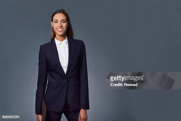 lächelnde junge geschäftsfrau hält dokument - blue suit stock-fotos und bilder