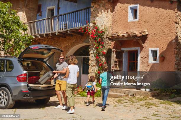 parents and children by car outside house - car arrival stock pictures, royalty-free photos & images