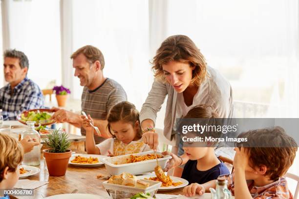 mutter, die speisen für kinder gegen fenster - lunch stock-fotos und bilder