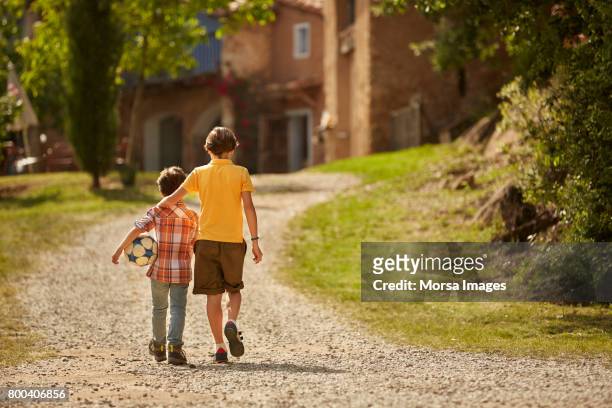 rear view of siblings walking on pathway - sibling stock pictures, royalty-free photos & images