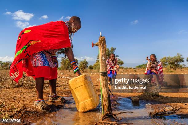 afrikansk kvinna från maasai stammen samla vatten, kenya, östafrika - african village bildbanksfoton och bilder