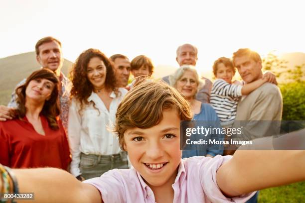 portrait of smiling boy against family in yard - multi generation family portrait stock pictures, royalty-free photos & images