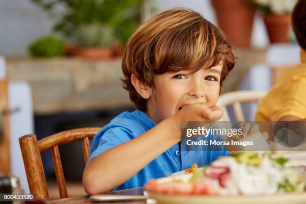 portrait of boy eating food at table in house - day 7 foto e immagini stock