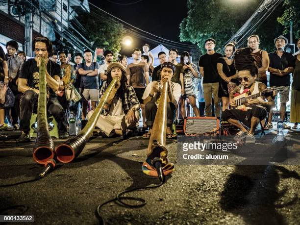 group of musicians playing at the sunday night market in chiang mai thailand - chiang mai sunday market stock pictures, royalty-free photos & images