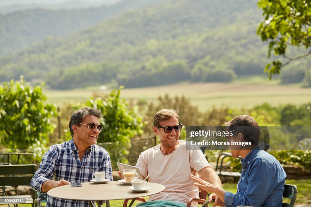 Happy friends talking while having tea in yard