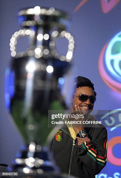 Jamaican American reggae and Grammy award winner singer Shaggy, who will interpret the official mascot song, gestures behind the trophy of the UEFA...