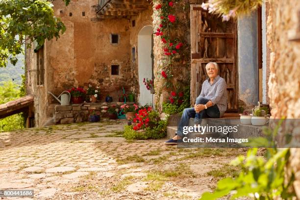 portret van lachende senior man zit op de veranda - spanje stockfoto's en -beelden