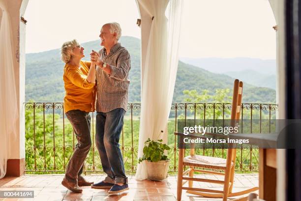 älteres paar tanzen in balkon zu hause zu lieben - elderly dancing stock-fotos und bilder