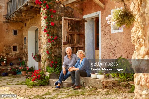 portrait of smiling senior couple sitting on porch - man blouse stock pictures, royalty-free photos & images