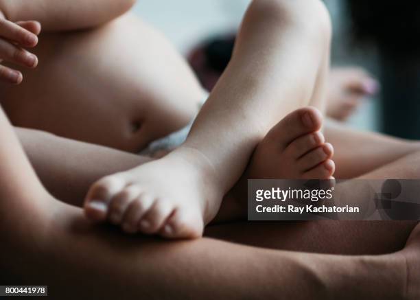 baby boy on mothers lap - baby skin fotografías e imágenes de stock