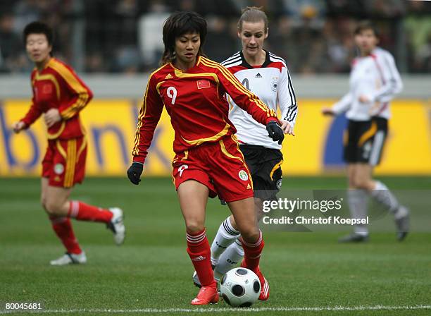 Simone Laudehr of Germany tackles Han Duan of China during the women's international friendly match between Germany and China at the Freiburg stadium...