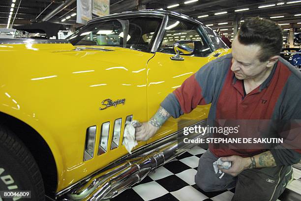 Man cleans his car on February 28 during the tenth edition of the "Paris Tuning and Racing Show" fair, that runs until next 03 March. AFP PHOTO...