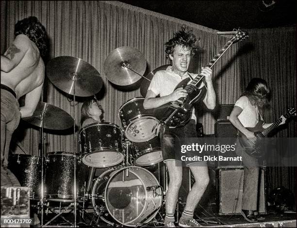 Bon Scott, Angus Young and Mark Evans of AC/DC performing on stage, Nashville Rooms, London on May 27, 1976.