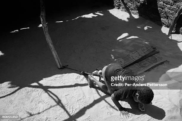 Mentally handicapped boy is tethered to a pole to prevent him from wandering away at the Oure Cassoni refugee camp on July 26, 2007 about 23...
