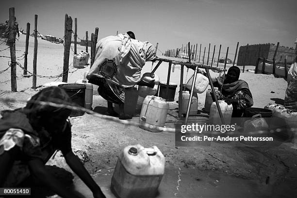 Refugees fetch water at the Oure Cassoni refugee camp on July 26, 2007 about 23 kilometers outside Bahai, Chad. Since 2003, Darfur's Janjawid militia...